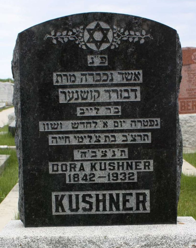 Black granite gravestone with Hebrew inscription above the English name Dora Kushner, 1842 to 1932